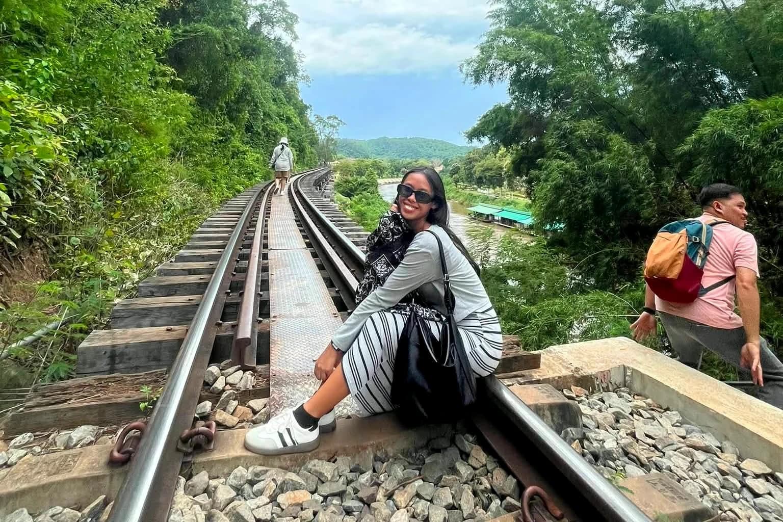 Traveler on the Death Railway tracks above the River Kwai on the Erawan day tour from Bangkok